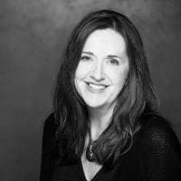 A black and white photo of a woman smiling.