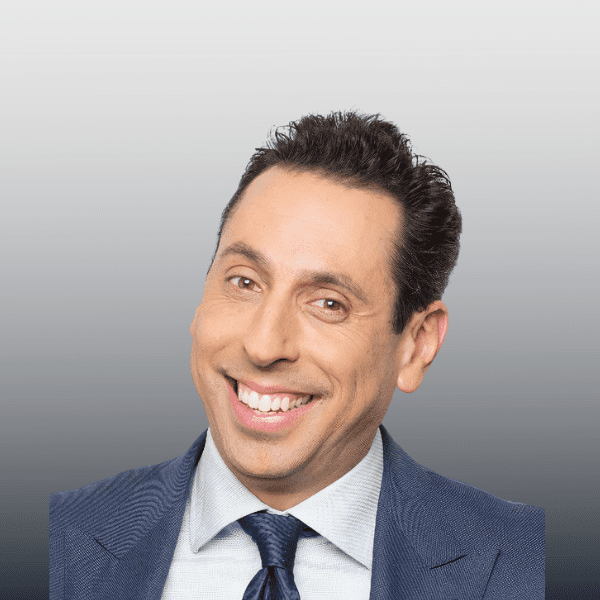 A man in a suit and tie smiling for the camera.