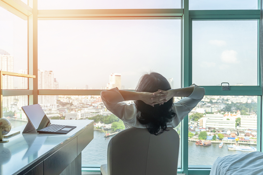 A woman sitting in her office relaxing and looking at the view
