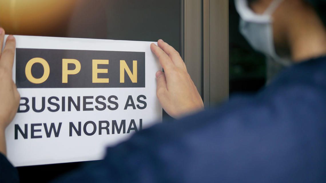 a person posting a poster that says open business as new normal