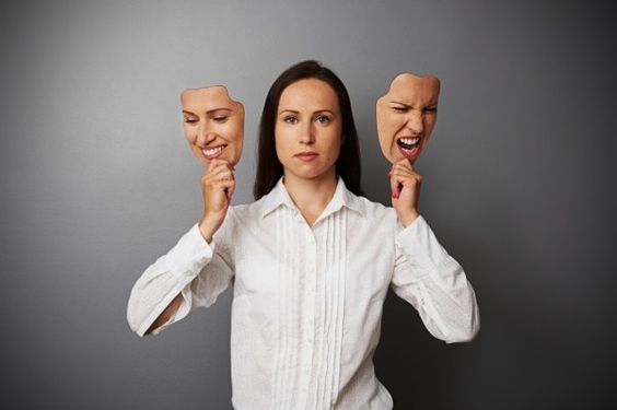 A woman holding two face-like masks