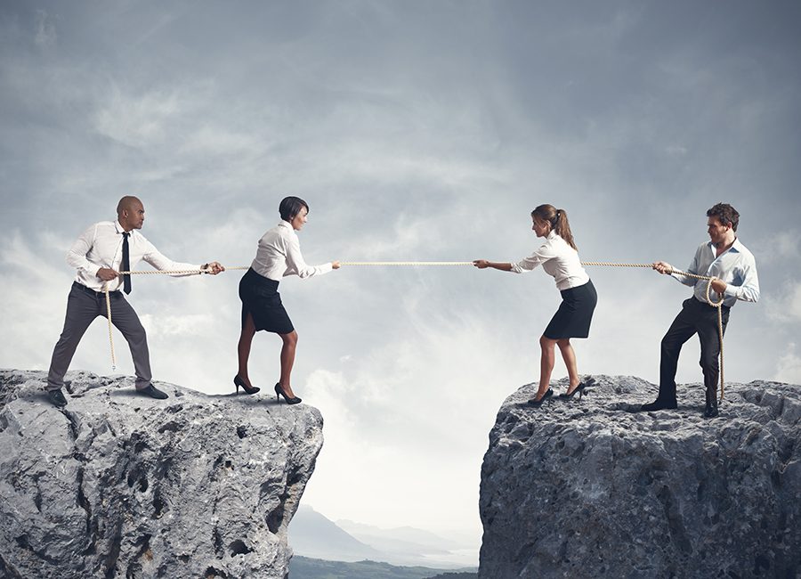 two pairs doing tug of war on top of two big rocks