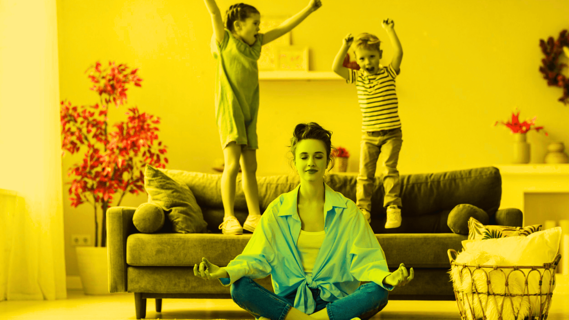 A woman meditating while a small girl and a boy jump on the couch