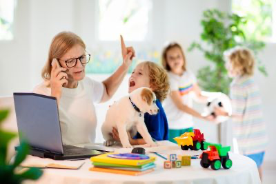 A woman talking on the phone while children in the background create a ruckus