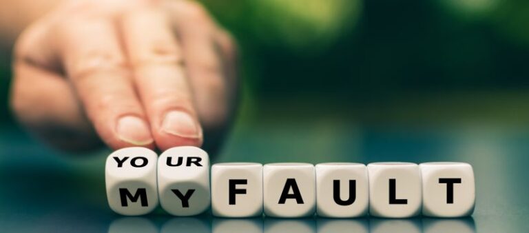 A person is holding out their hand over the word " fault ".