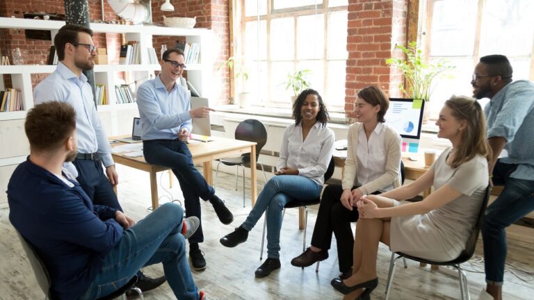 A group of people sitting in chairs around each other.