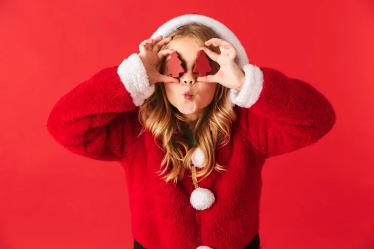 Girl holding Christmas trees in front of her eyes to celebrate the holidays