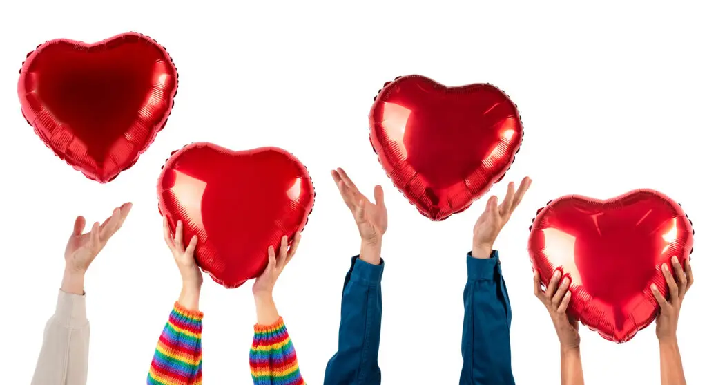 Valentines holding up their balloons to listen with their hearts
