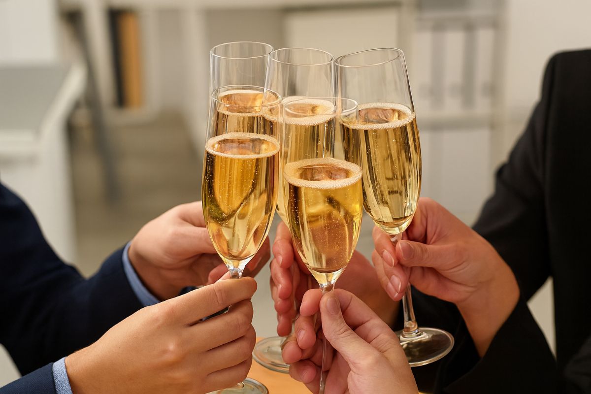 Office celebration with coworkers toasting champagne glasses, capturing the spirit of success, teamwork, and camaraderie in an office drinking moment.
